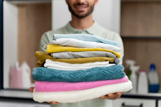 man-holding-pile-clean-clothes_23-2149117026